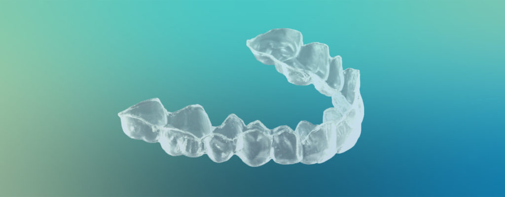 Clear at-home teeth whitening tray against a blue-green gradient background