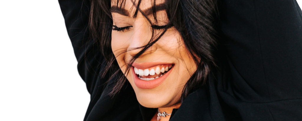 Smiling woman with bright white teeth, representing the results of internal bleaching treatment