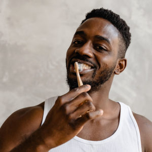 Patient brushing his teeth after visiting our dentistry for a dental cleaning in Raleigh, NC