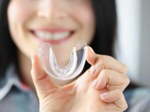 Patient holding a my-functional therapy appliance to improve TMJ disorders